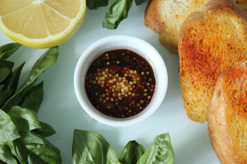 Sliced toasted French baguette with sauce and a slice of lemon