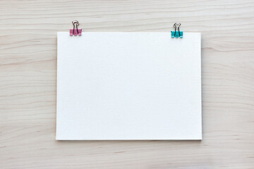 School office supplies on wooden background. Back to school concept. White board with hands for copy space. Top view ready for your design