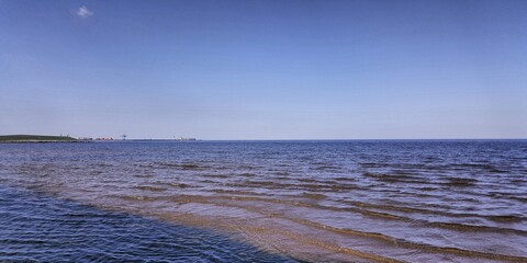 Obraz premium On the seascape, the waters of the Gulf of Finland, a light breeze, shade from the coast and blue summer skies.