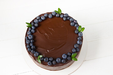 Delicious chocolate  cake with fresh   blueberry ,  top view , white  wooden board
