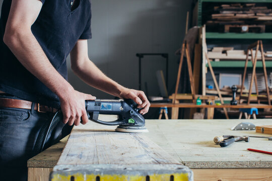 Carpentry - Close Up of Young Man Using Random Orbital Sander on Plank of Wood