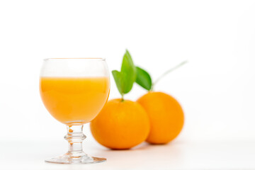 Orange juice in glass and fresh orange fruit on white background.