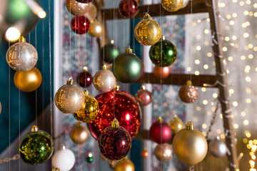 Fototapeta na wymiar New Year party decoration. Christmas Tree Art Installation Made with String Lights and Christmas Balls Hanging on Threads. Selective focus.Christmas Decoration. Creative, modern and stylish decor.