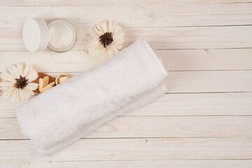 Obraz na płótnie Canvas White towel cosmetics bathroom accessories wooden background scenery