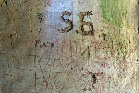 Graffiti written and engraved into an old wall