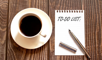 To Do List - white paper with pen and coffee on wooden background