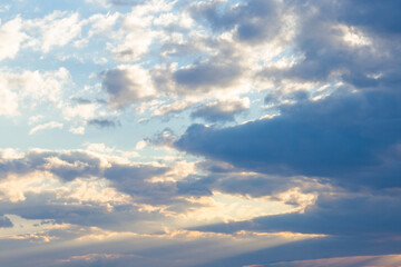 clouds in yellow sunset light. blue sky background in the evening