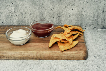 Corn cheese, snacks with sauce on a wooden stand. Beer snack, dish on the menu. Close up.