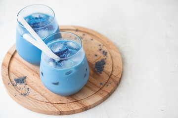 iced blue matcha tea with milk in glass on a board