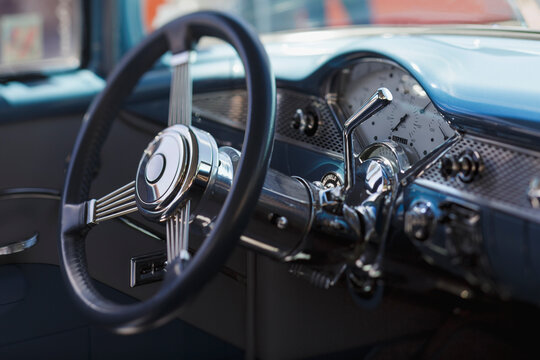 A vintage cars steering wheel and dashboard
