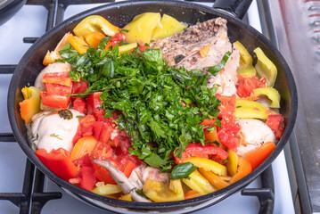 Cooking chicken with peppers, tomatoes and herbs according to a classic Italian recipe in a pan - Roman chicken, close-up, top view