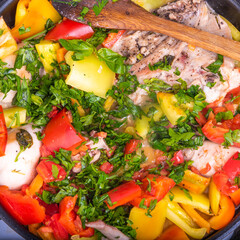 Cooking chicken with peppers, tomatoes and herbs according to a classic Italian recipe in a pan - Roman chicken, close-up, top view