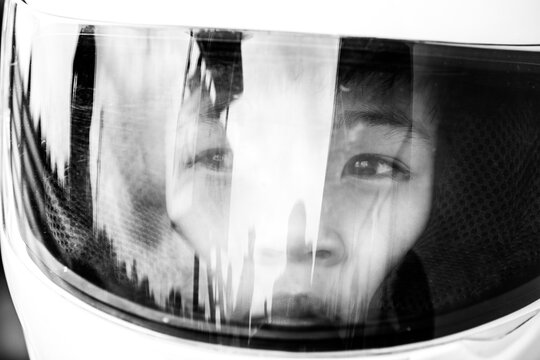 Young boy wearing helmet in deep thought before a race