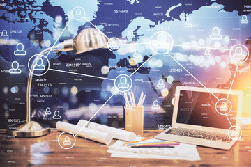 Computer on desktop with social network hologram. Double exposure. Concept of international people connections.