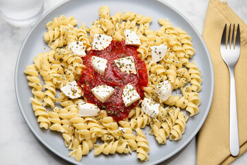 Pasta with tomato sauce and cheese on a marble table