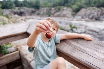 LIttle guy eating cherries while taking in the sights at Great Falls, Maryland