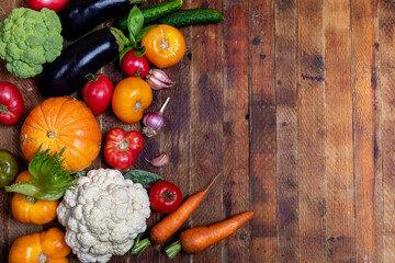 Harvest of fresh farm vegetables on old rustic weathered vintage wooden table. View above. Copy space.