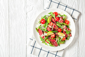Beef steak salad on a plate, top view, copy space