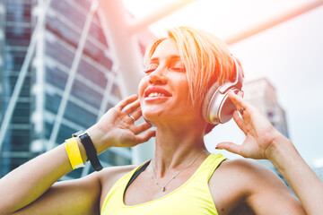 Sport woman happy enjoy with wireless music headphone urban outdoors background.