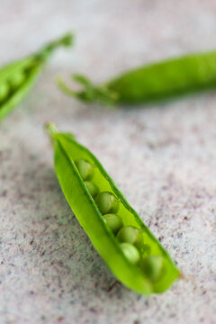 Macro catch of green peas in pod on stone table