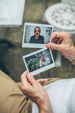 Senior couple looking at polaroid photos of themselves