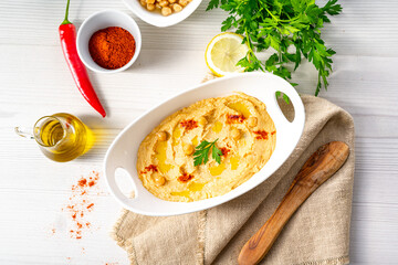 hummus paste with lemon and chilli on white background