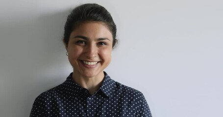 Head shot close up of indian 25s woman pose on gray studio background. New company member intern successful ambitious employee portrait, girl with charming smile, dentistry services clinic ad concept