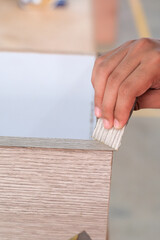 Young carpenter applying  edging strips