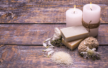 Spa composition from natural aromatic handmade soap, candles and perfumed salt on a wooden background, top view, copy space.