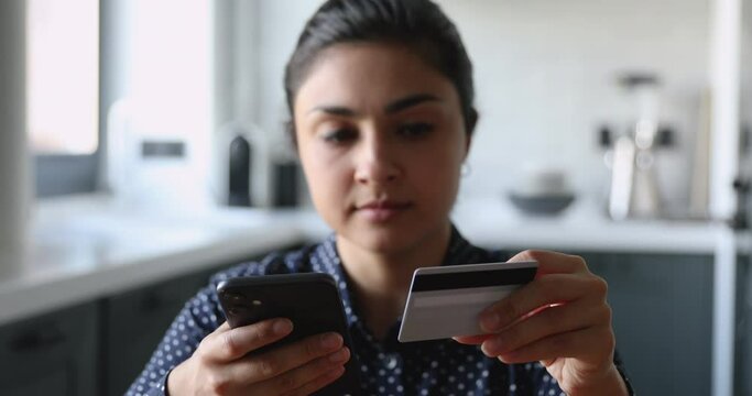 Upset indian woman hold smartphone check balance use on-line banking service has financial problems feels irritated close up. Internet fraud bankruptcy, debt and overspend, blocked credit card concept
