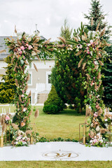 Fototapeta na wymiar Wedding decor. The arch is decorated with different colors flowers.