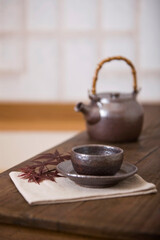 teacup and teapot with maple leaf on table
