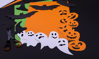 Papercraft cut simbols of Halloween - bats, ghosts and colorful paper.