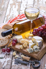Set with wine, cheese and fresh natural grape fruits on a wooden board.