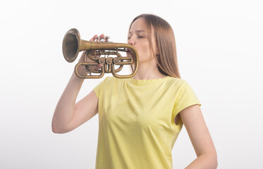 young caucasian woman holding trumpet and playing it isolated on white background