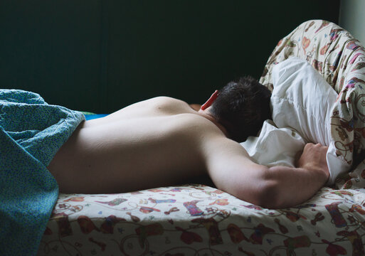 Grown man asleep on cowboy print sheets
