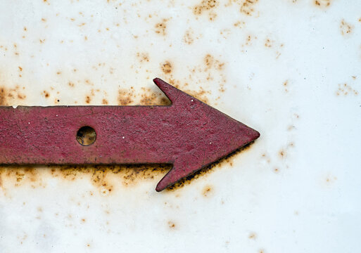 red metal arrow on a rusty white background