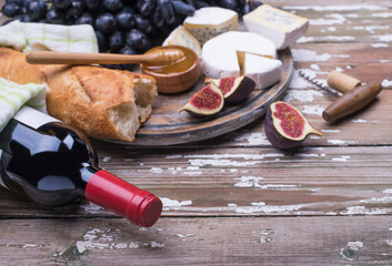 Bottle of red wine with fresh natural organic products cheese and fruits.