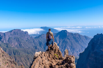 A young man after finishing the trek at the top of the volcano of Caldera de Taburiente near Roque de los Muchachos one summer afternoon, La Palma, Canary Islands. Spain