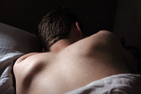 Bare Upper Back Of Young Man Sleeping