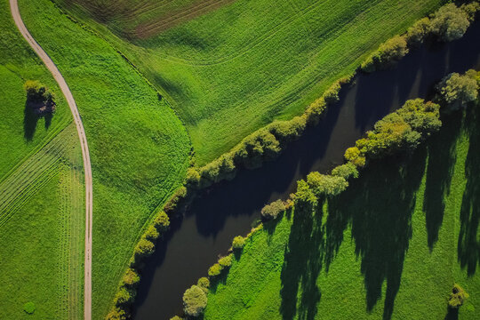 Vertical aerial view of Unica or Unec river on Planinsko polje field in the late summer. Green fields and forests seen from above.