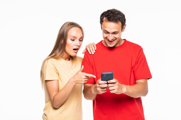 Young man and surprised woman are watching on the phone isolated on white background