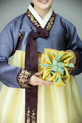 Fototapeta na wymiar young woman in korean traditional clothing holding gift box