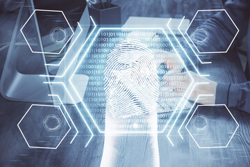 Fingerprint hologram with businessman working on computer on background. Security concept. Double exposure.