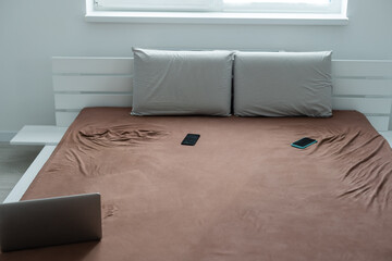 a laptop on a brown bed