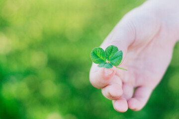 Four leaf clover held between fingers