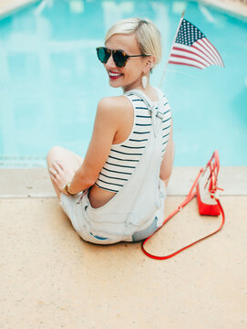 A young woman celebrates fourth of july by the pool