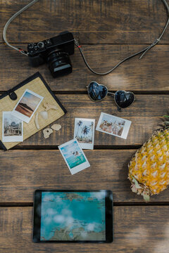 Tablet Computer With Travel Map And Polaroids On The Table