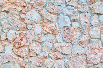 Wall with chaotic stones location. Texture of Surface. Pink and blue colour mix. Natural material background. Copy space
