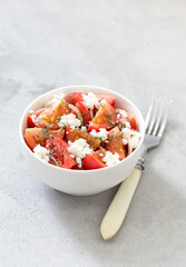 Fresh tomato salad with cottage cheese, onion, dill in a bowl on a light background